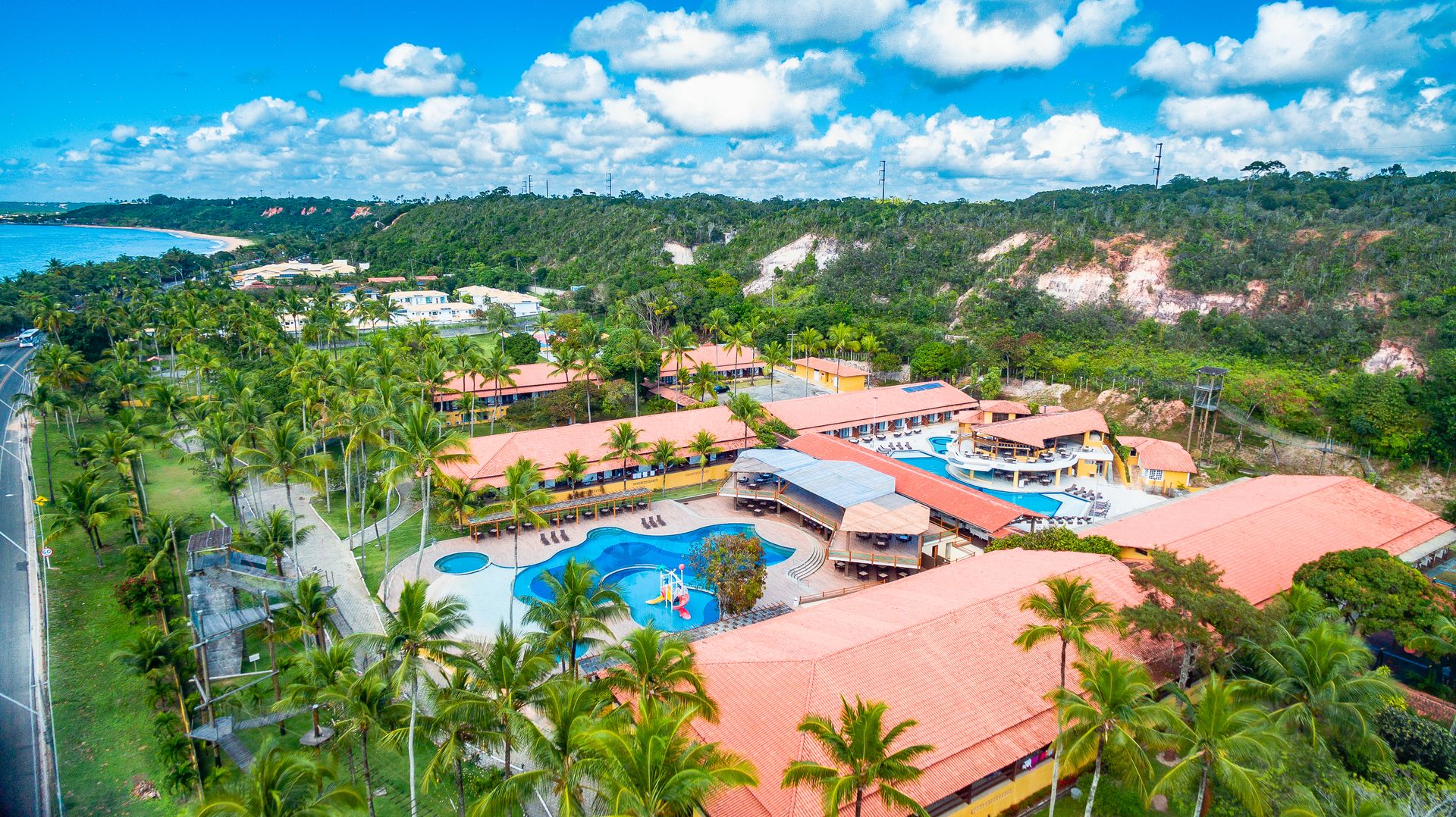 Vista aérea do Porto Seguro Praia Resort com piscinas, coqueiros e mar em Porto Seguro Bahia